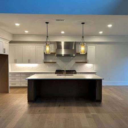 Retro bathroom with brown and white geometric tiles, a large mirror, and built-in vanity unit. Greco-Roman motifs decorate the walls.